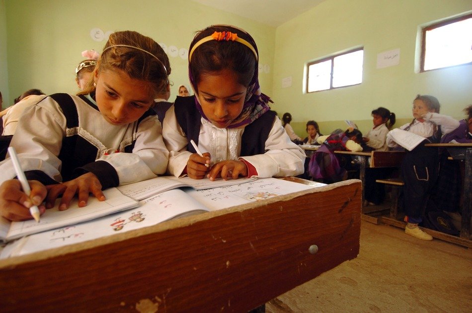 cute asian children at desks in classroom, iraq