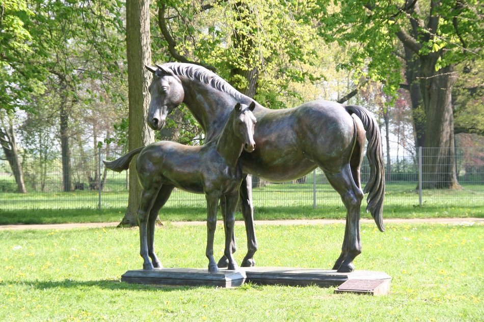 mares with foal, bronze sculpture in park, germany, neustadt
