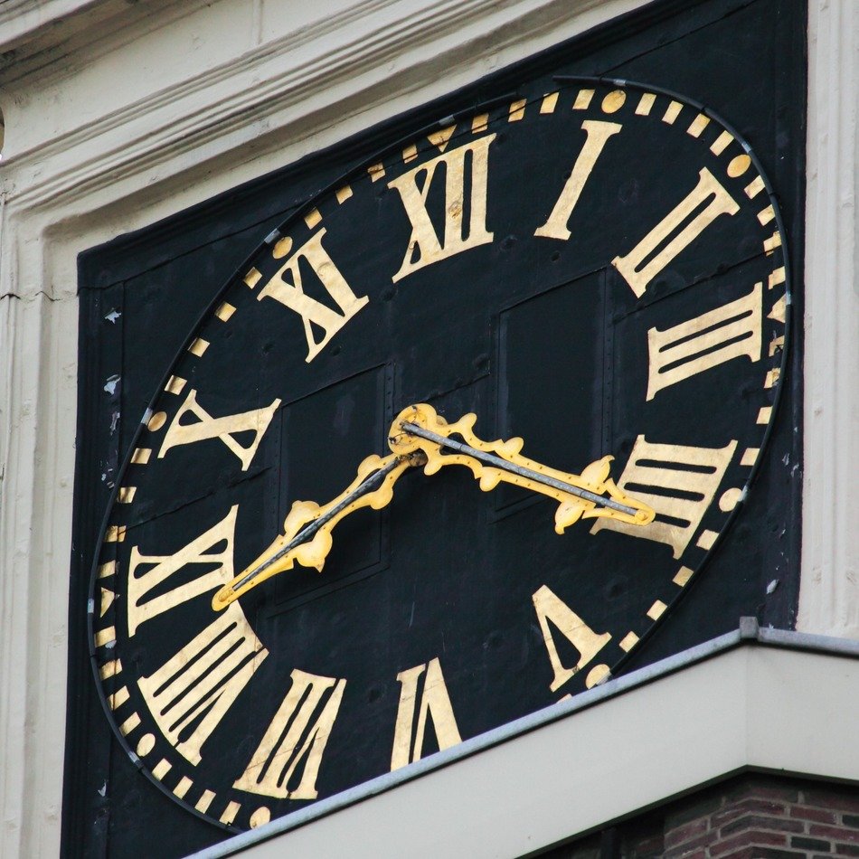 classic gloden clock on facade, amsterdam