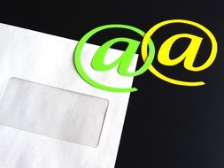 Yellow and green "@" symbols on a white envelope background