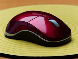 red computer mouse at pad