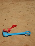 blue and red shovel in the sandbox