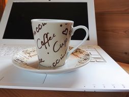 coffee cup on white laptop