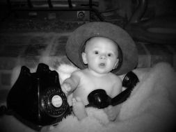 child with old telephone in black and white image