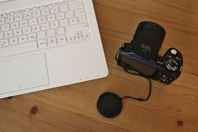 Top view of the camera and white laptop on the desk