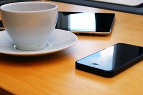 a cup of coffee in the office on the background of the smartphones