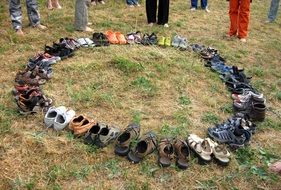Colorful shoes in circle and barefeet people on lawn