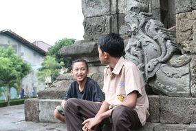 indonesian boys chatting at ancient wall