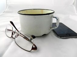 grunge mug, glasses and phone at white background