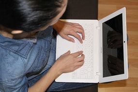 Top view of a man at work with a white laptop