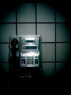 black white photo of old phone on the wall