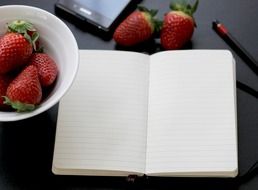 clean notebook and a plate of strawberries