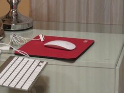 white keyboard, white mouse and red computer pad on the table