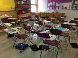 desks with notebooks in classroom
