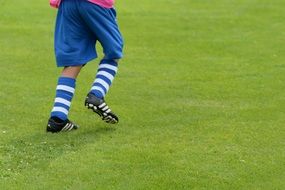 young boy playing football in kick shoes