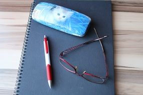 Notebook,pen and glasses on the table