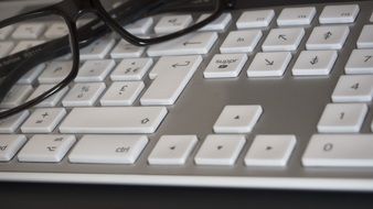 Glasses on the keyboard with white keys