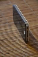 iphone 4 stands on a wooden surface