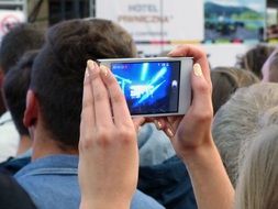 woman shoots a concert on the phone