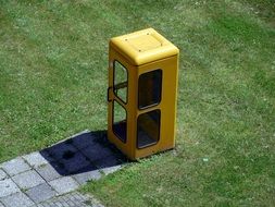 yellow phone booth on the lawn