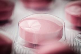 Pink round tablets in a blister close-up