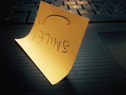 smile, lettering on yellow paper upside down