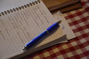 write in a notebook and a blue pen