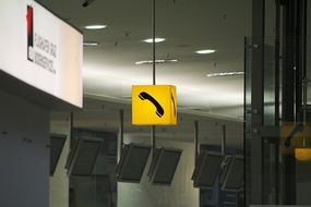 yellow sign with a black telephone in the hall