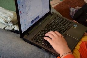 black laptop on knees of man