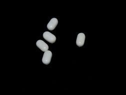 white pills on black surface