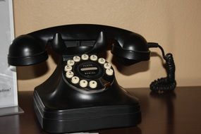 vintage black disk phone on desk