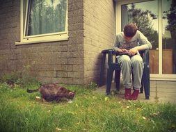 a boy with a tablet and a cat in the garden