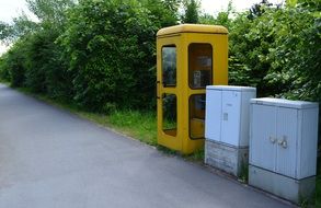 yellow telephone box and switchbox on the street