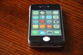 Black cell phone on a wooden surface