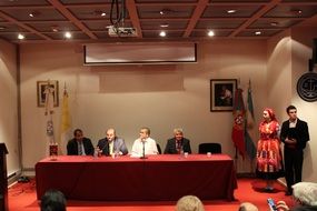 mature men at table and man with woman in traditional Portuguese clothing in hall