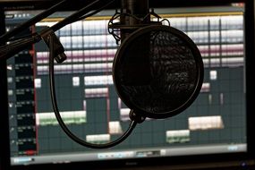 Microphone in sound studio on a background of a laptop with the software