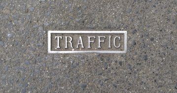 traffic, silver lettering on grey textured surface