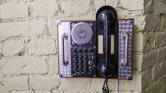 vintage phone apparatus on brick wall