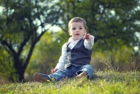 child sitting on the grass in the Park