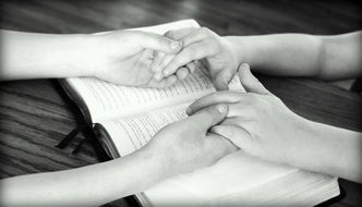 hand in hand on the book black and white photo