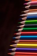 colored wooden pencils on a black background