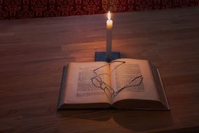 glasses book and candle on desk