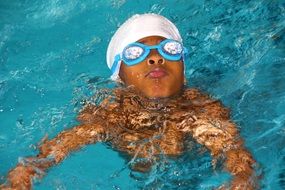 child in swimming glasses in the pool
