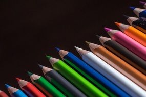 colored crayons on a black background