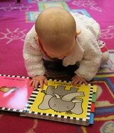 child with colorful pictures on the carpet