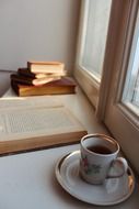 a book and a cup of tea on the windowsill