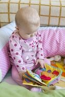 small baby looking at toy book