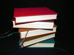 books with color covers on a black background