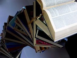 top view of the open book lying on the stack of books