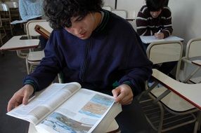 student reading a book in class